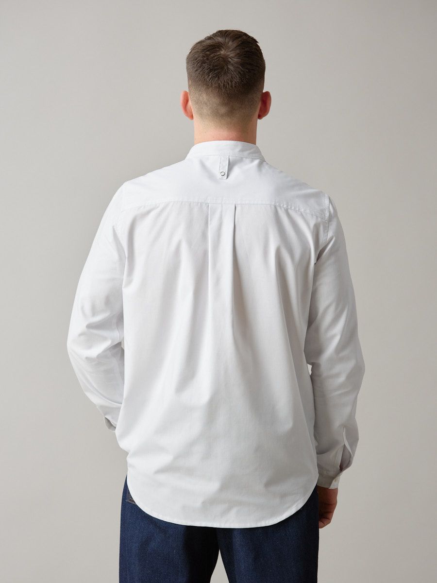 Hvid herreskjorte med lange ærmer. Kinakrave og manchetter. Gennemknappet med detalje på forstykket.