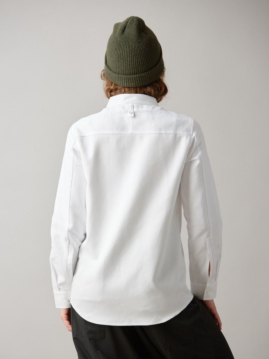 Hvid skjorte med lange ærmer. Kinakrave, brystlomme og synlig knaplukning.